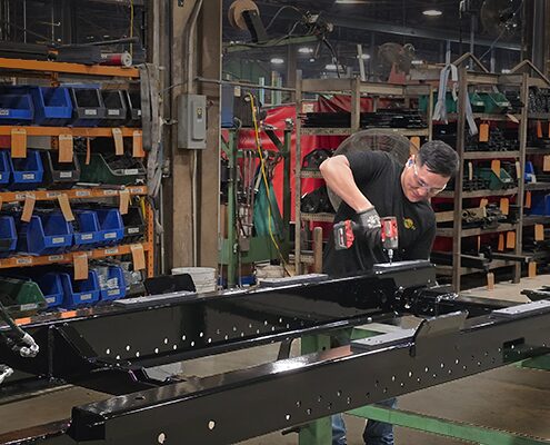 SwapLoader manufacturing team member using a drill to assemble a hoist